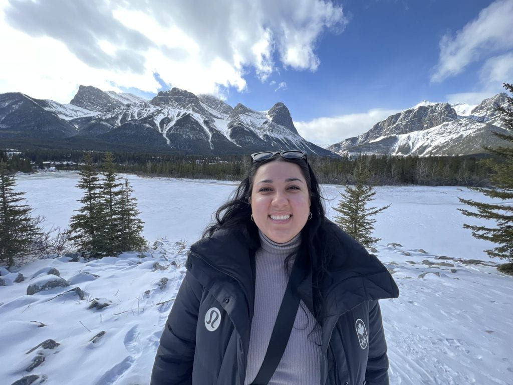 A picture of Natassia smiling in front of mountains.